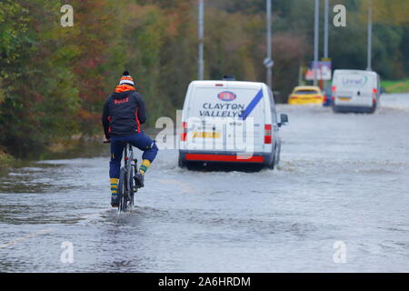 Un cycliste suit les automobilistes par les inondations sur le chemin Barnsdale en Castleford après 24 heures de pluie Banque D'Images