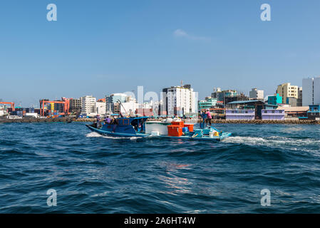 Male, Maldives - Le 18 novembre 2017 Transport : bateau naviguant dans la mer en arrière-plan de l'île de Male. Paysage urbain de la ville au bord de l'homme que se Banque D'Images