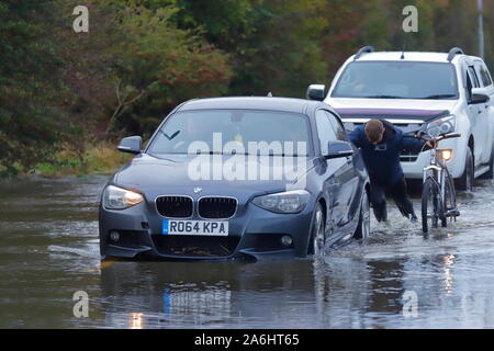 Les bons samaritains pousser une voiture hors de l'eau d'inondation après s'être échoué sur le chemin Barnsdale à Castleford. Banque D'Images