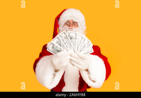 Santa heureux gagner la loterie et de l'argent dollar holding sur orange Banque D'Images