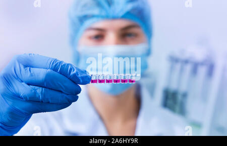 Femme au masque et des gants en latex préparation du matériel pour les tests Banque D'Images