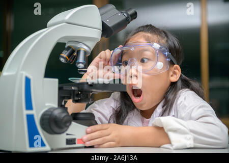 Peu scientifique est excité sur les expériences scientifiques après l'utilisation de microscope, de l'éducation science concept Banque D'Images