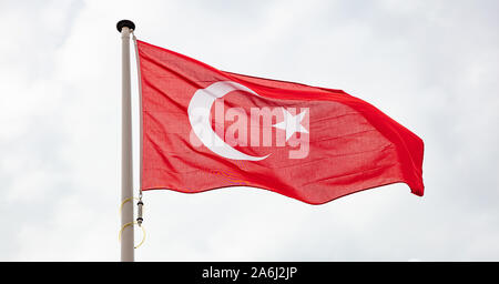 Drapeau de la Turquie. Signe et symbole national turc forme sur un mât against cloudy sky background Banque D'Images