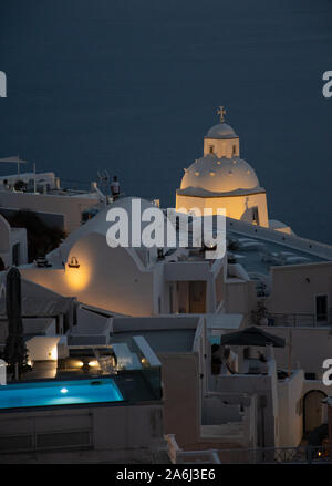 Fira, Grèce - 14 juillet 2019 : une nuit coup d'une piscine éclairée et le dôme d'une église, vu de Ipapantis Banque D'Images