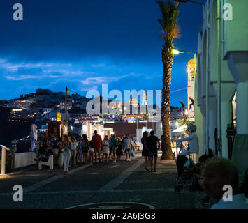 Fira, Grèce - 14 juillet 2019 : Nuit coup de touristes marchant le long de la falaise route de Ipapantis Banque D'Images