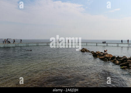 Les gens à pied par le pont de l'infini (Den Uendelige Bro) en forme de cercle - jetée en bois construit sur un littoral de la Baie d'Aarhus sur une plage de Varna/Ballehage Beach, créé par l'architecte Niels Povlsgaard Gjødes et Johan sont vus à Aarhus, Danemark, le 30 juillet 2019 © Michal Fludra / Alamy Live News