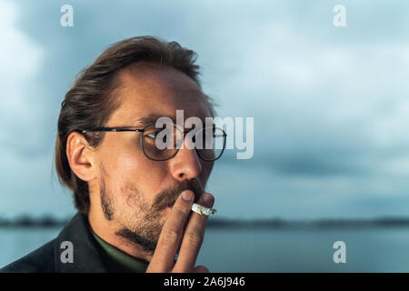 La photo en gros plan d'un man smoking a cigarette Banque D'Images