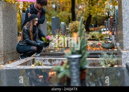 Couple dans la douleur sur un cimetière en automne Banque D'Images