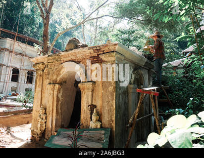 Le travail de restauration effectué par un travailleur de la jungle cachée temple de Wat Pha Lat dans Chiang Mai, Thaïlande. Banque D'Images