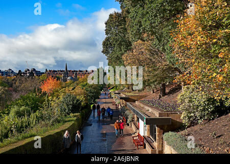 Les gens qui marchent dans le feuillage d'automne à Sunshine, West Princes Street Gardens, Édimbourg, Écosse, Royaume-Uni Banque D'Images