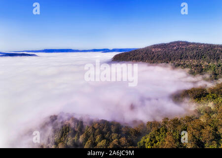 Plus de précipitations visuelle Kangaroo Valley en Australie - nuage blanc épais couvre scenic vale entre les chaînes de montagnes de grès on a bright sunny mor Banque D'Images