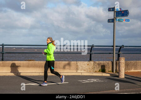 Southport, Royaume-Uni. 27 Oct, 20192 Chilly vent et ciel bleu sur la côte que les joggeurs prendre dans la brise de mer et profiter d'un exercice léger le long de la promenade du front de mer à marée haute. /MediaWorldImages AlamyLiveNews. Banque D'Images