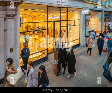 Les amateurs de shopping et les lumières du début de la soirée dans les magasins de Piccadilly, Londres Banque D'Images