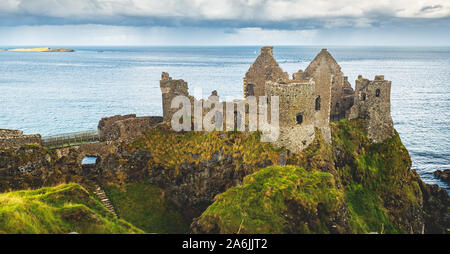 Ancien château en ruines au bord de mer de l'Irlande du Nord. Reste de l'édifice médiéval, ciel nuageux et l'océan sur l'arrière-plan. Beau paysage et architecture de paysage Campagne Vue aérienne Photo Banque D'Images