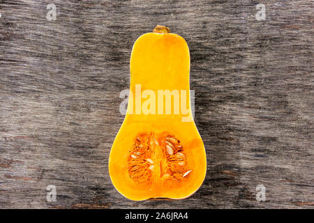 Pumpkin sur une table en bois noir. Sweet orange citrouille en forme de poire. La moitié pumpkin cutted sur milieu Banque D'Images