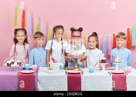 Funny Girl, dans les verres holding creative yummy cake, aller à traiter son guestss. la photo en gros. isolatd sur fond rose, Banque D'Images