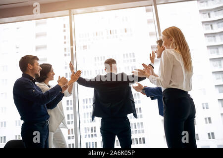 Joyeux collègues friendly greeting, félicitant leur nouveau chef, vue arrière photo. Nous l'avons fait.le bonheur, sentiment positif et l'émotion. ma a Banque D'Images