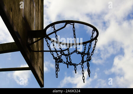 Ancienne chaîne de basket-ball panier vue rapprochée avant ciel nuageux Banque D'Images