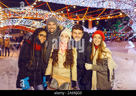 Sourire d'amis s'amuser la nuit dans Noël. Banque D'Images