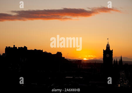 Calton Hill, Édimbourg, Royaume-Uni. 27 octobre 2019. Météo britannique. De soleil colorés sur le centre-ville en donnant une silhouette du château de Balmoral Hotel tour de l'horloge, un froid de 10 degrés. Banque D'Images