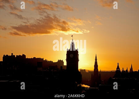 Calton Hill, Édimbourg, Royaume-Uni. 27 octobre 2019. Météo britannique. De soleil colorés sur le centre-ville en donnant une silhouette du château avec Scott Monument et Balmoral Hotel tour de l'horloge, un froid de 10 degrés. Banque D'Images