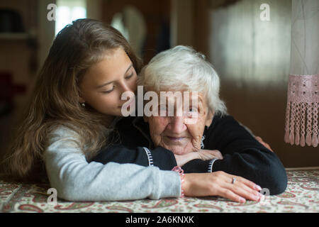 Portrait of a cute little girl hugging une vieille mamie. Banque D'Images