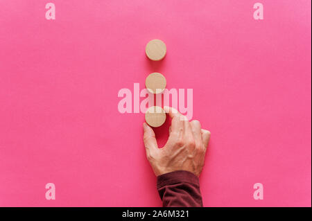 Placer la main mâle blanc coupé en trois cercles sur fond rose. Avec l'exemplaire de l'espace. Banque D'Images