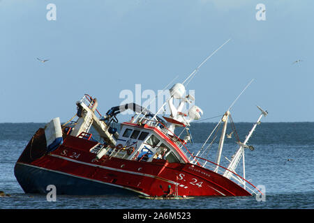 Le comté de Down, Irlande du Nord, Royaume-Uni. 27 Oct, 2019. Un homme dans un kayak passe le chalutier de pêche endommagés le Dillon Owen à Ardglass, comté de Down, Dimanche 27 Octobre, 2019. Le chalutier se préparait à entrer Ardglass Harbour tôt mercredi 23e lorsqu'il a perdu le pouvoir et a couru sur des rochers. L'Administration portuaire de la pêche de l'Irlande du Nord a déclaré qu'elle se préparait à quai pour décharger sa cargaison de harengs lorsqu'il a perdu le pouvoir. L'équipage de la Dillon Owen, enregistrée dans le comté de Cork, ont été transportés par l'hélicoptère des garde-côtes et il n'y a pas de blessés. Crédit : Paul McErlane/Alamy Live News Banque D'Images