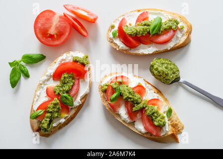 Toast avec soft fromage mascarpone, tomates et pesto de basilic frais Banque D'Images