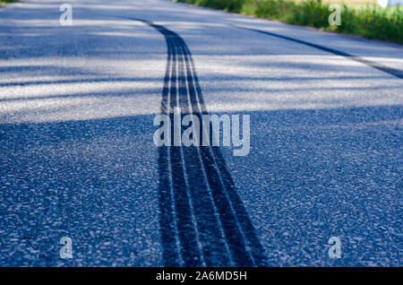 Traces après un freinage soudain sur une route étroite avec surface asphaltée. Banque D'Images