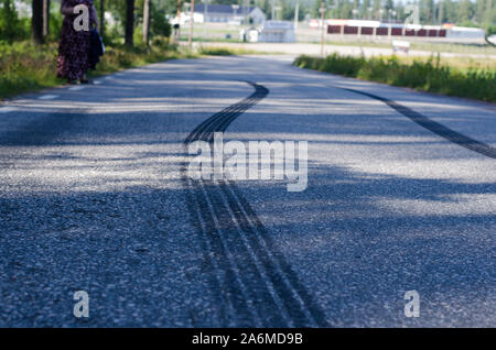 Traces après un freinage soudain sur une route étroite avec surface asphaltée. Banque D'Images