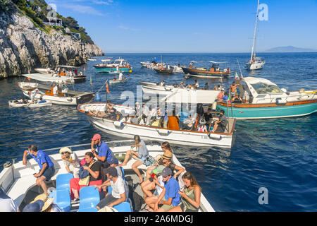 Île de Capri, ITALIE - AOÛT 2019 : Les Visiteurs dans de petits bateaux attendent de voir la "Grotta Azzurra" ou "Blue Grotto' cave sur la côte de Capri Banque D'Images