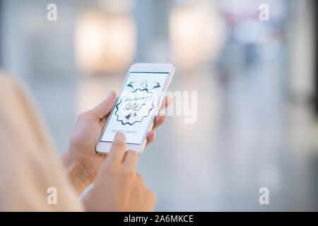 Mains de girl holding smartphone et entrer boutique en ligne Banque D'Images