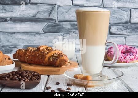 Délicieux petit-déjeuner. Latte macchiato café avec divers bonbons. Banque D'Images