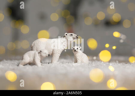 Figurines décoratives d'un thème de Noël. Statuettes d'une famille d'ours polaires. Décoration d'arbre de Noël. Décor de fête, chaud bokeh lights Banque D'Images