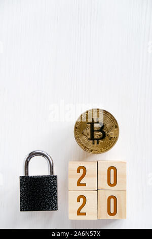 Les numéros de 2020 avec Bitcoin sur fond de bois blanc, cubes, serrure. Concept de sécurité Cryptocurrency dans la nouvelle année. Télévision lay, Close up. Copier l'espace. Vertic Banque D'Images