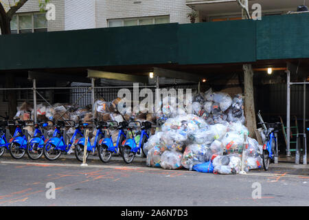 Un tiercé organisé d'ordures, trottoir, échafaudage et citibikes à New York City Banque D'Images