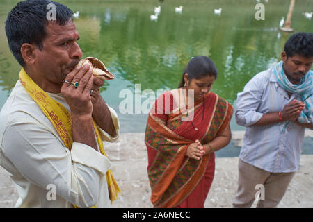 Au cours d'un rituel Shraddha honorer un couple du parent décédé, un prêtre hindou souffle une conque shankh (Sacré) ; Banganga Tank, Mumbai, Inde Banque D'Images