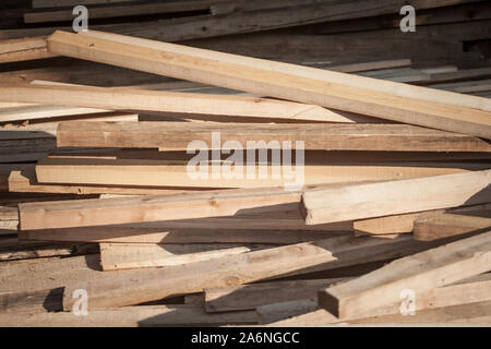 Planches en bois, des tiges et des poteaux, les stockes dans les piles et des piles, en attente d'être utilisé comme bois d'œuvre par un charpentier sur un chantier de construction. Photo de pi en bois Banque D'Images