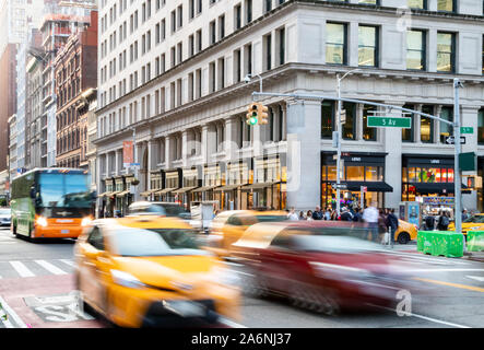 NEW YORK 2019 : voitures, taxis et autobus vitesse à travers l'intersection achalandée de 23e Rue et 5e Avenue, au cours d'une longue après-midi Rush hour commute Banque D'Images