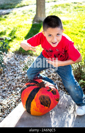 Happy boy montre fièrement l'Halloween citrouille il peint Banque D'Images