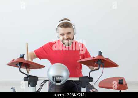 Les émotions, les passe-temps, de musique et de personnes concept - batteur émotionnel joue de la batterie électronique. Banque D'Images