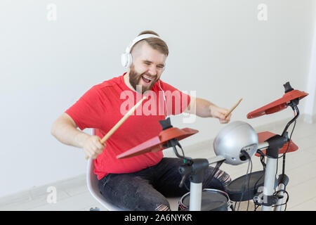 Émotions, batterie électronique et personnes concept - jeune homme batteur jouant du tambour. Banque D'Images