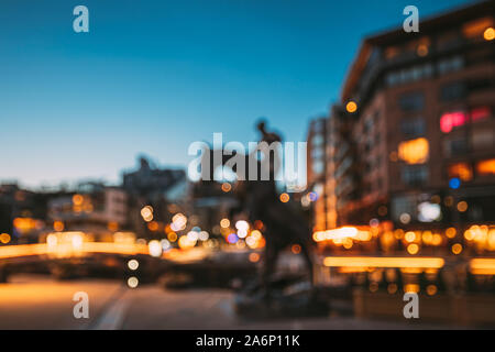 Oslo, Norvège. Nuit Résumé Boke Bokeh Background Effet. Statue de cheval dans la rue et les maisons à plusieurs étages dans quartier Aker Brygge. Somme Banque D'Images