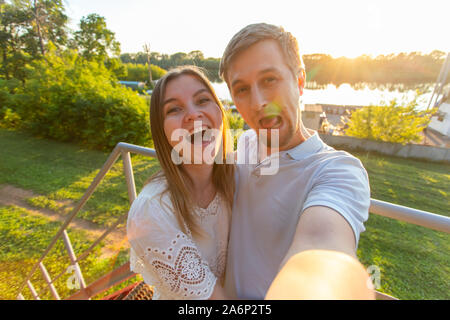 La Capture de moments lumineux. Jeune couple aimant faire joyeuse sur selfies caméra lors de standing outdoors Banque D'Images