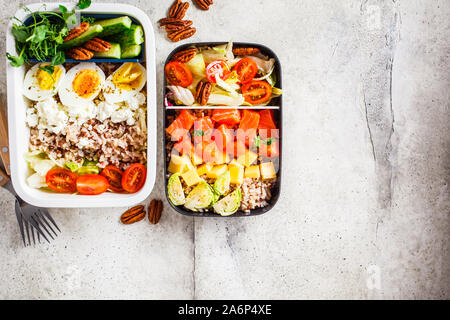 Boîte à lunch avec des aliments sains, équilibrés vue d'en haut. Riz au poisson, fromage, oeufs et légumes dans des contenants alimentaires. Banque D'Images