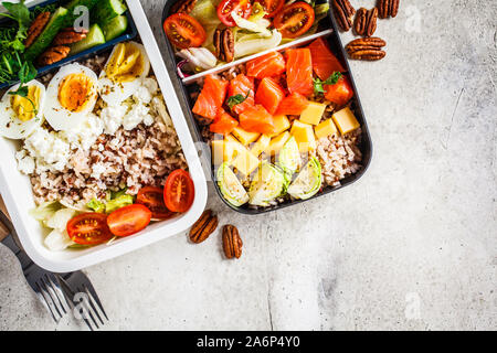 Boîte à lunch avec des aliments sains, équilibrés vue d'en haut. Riz au poisson, fromage, oeufs et légumes dans des contenants alimentaires. Banque D'Images