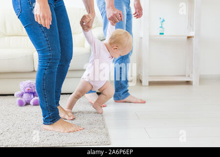 La famille, les enfants et la parentalité concept - enseignement parents baby girl de marcher Banque D'Images