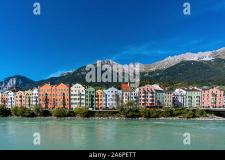 Vue panoramique de bâtiments colorés dans la ville autrichienne Innsbruck avec la rivière Inn dans l'avant-plan et mountainsof les Alpes en arrière-plan o Banque D'Images