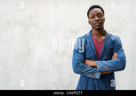 Handsome Young African man wearing denim jacket contre le béton Banque D'Images